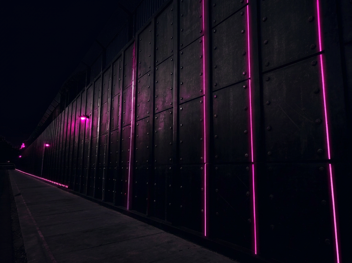Wall of black shield plates with magenta light seams